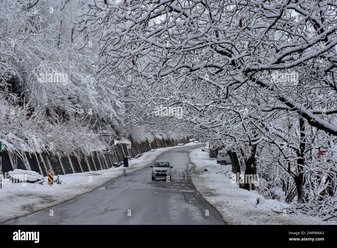 Vehicle on snow-covered road in Kashmir, illustrating Pakistan snow forecast impacts.