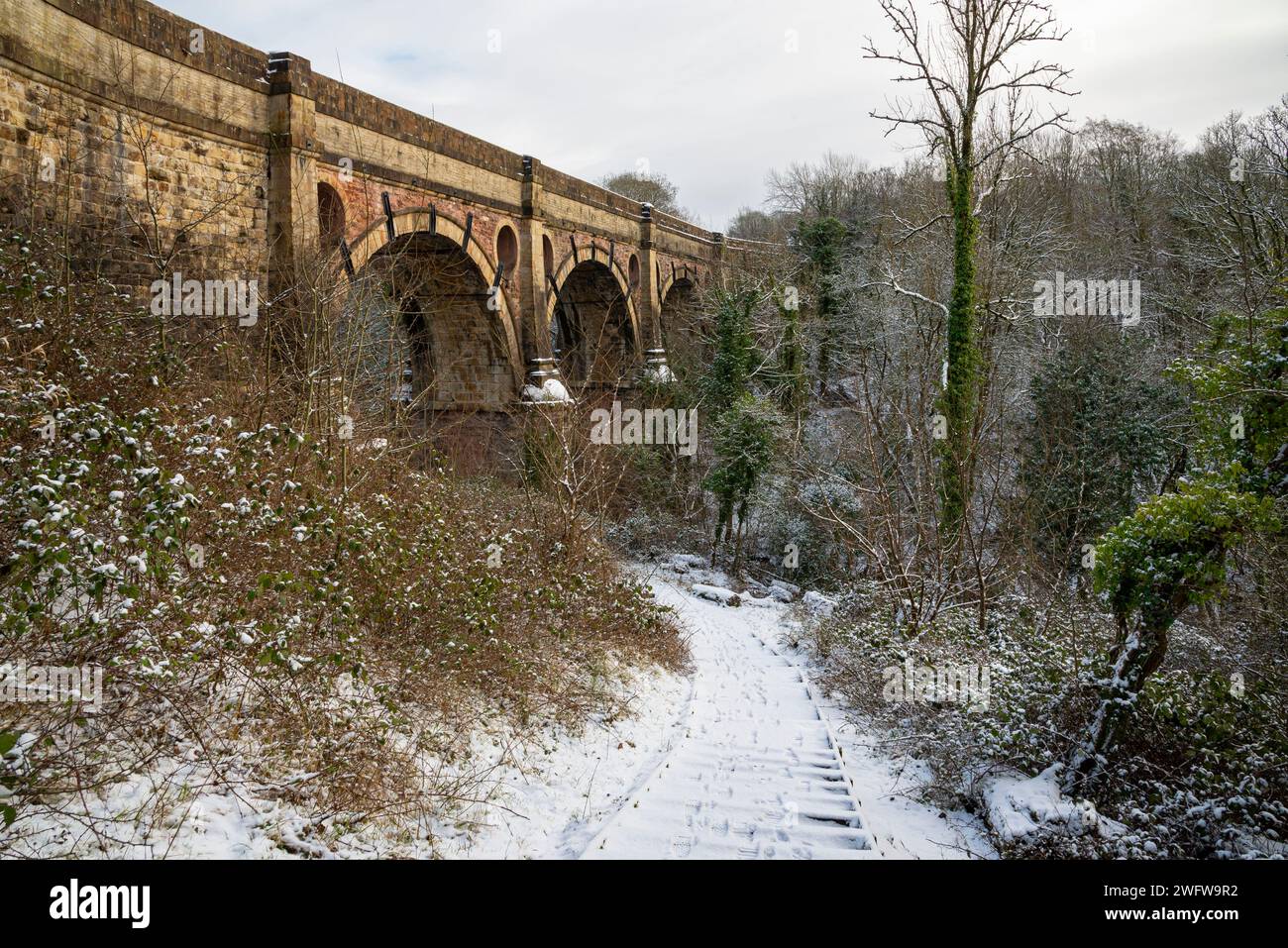 A snowy morning on the Peak Forest Canal at Marple, Stockport, Greater Manchester, England. View of the historic Marple Aquaduct. Stock Photo
