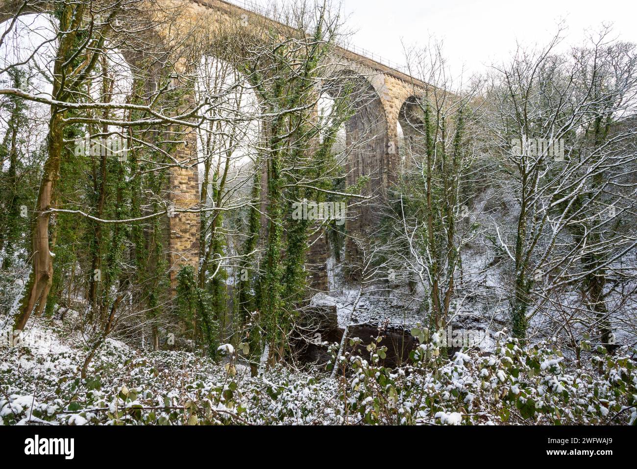 A snowy morning on the Peak Forest Canal at Marple, Stockport, Greater Manchester, England. The railway viaduct over the river Goyt. Stock Photo