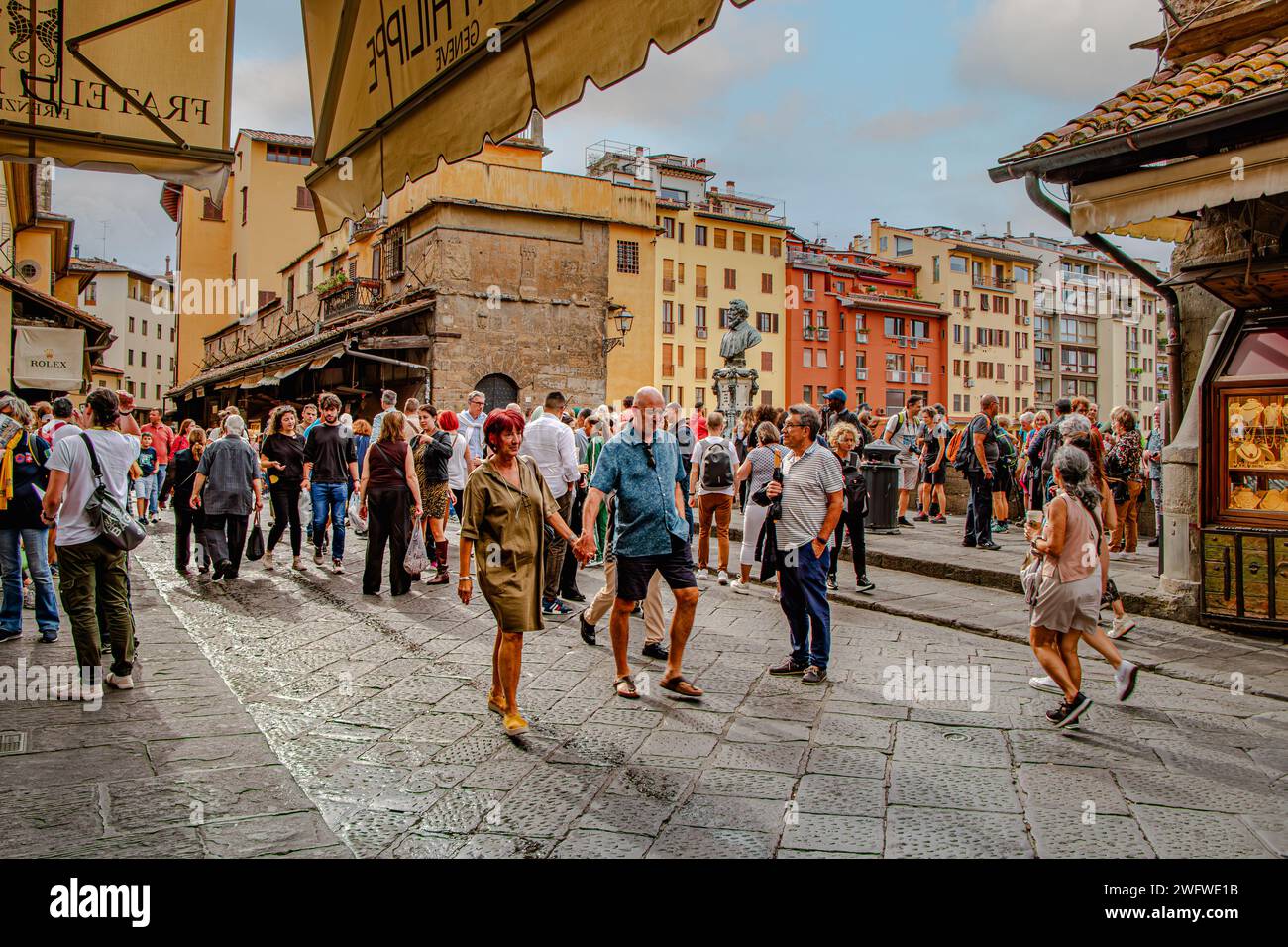Crowds of people walking on the Ponte Vecchio bridge browsing the many
