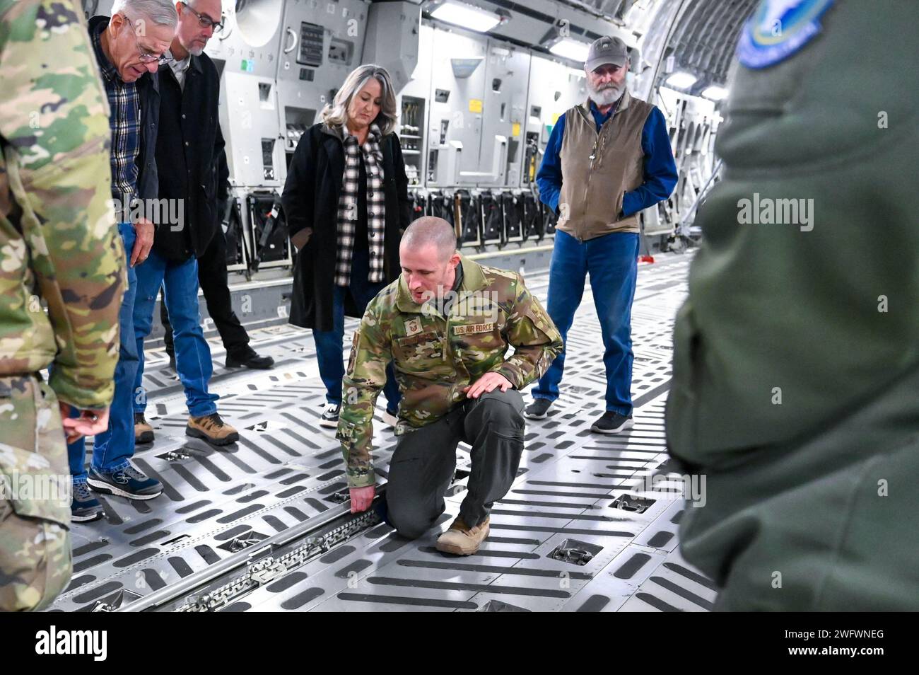 U.S. Air Force Senior Master Sgt. Joseph Vondohlen (middle), 56th Air Refueling Squadron senior enlisted leader, shows members of the Altus agricultural community the inside of a C-17 Globemaster III during the Airpower and Agriculture: Base Tour at Altus Air Force Base, Oklahoma, Jan. 12, 2024. Attendees were able to learn how the aircraft supports strategic transport of cargo and troops. Stock Photo