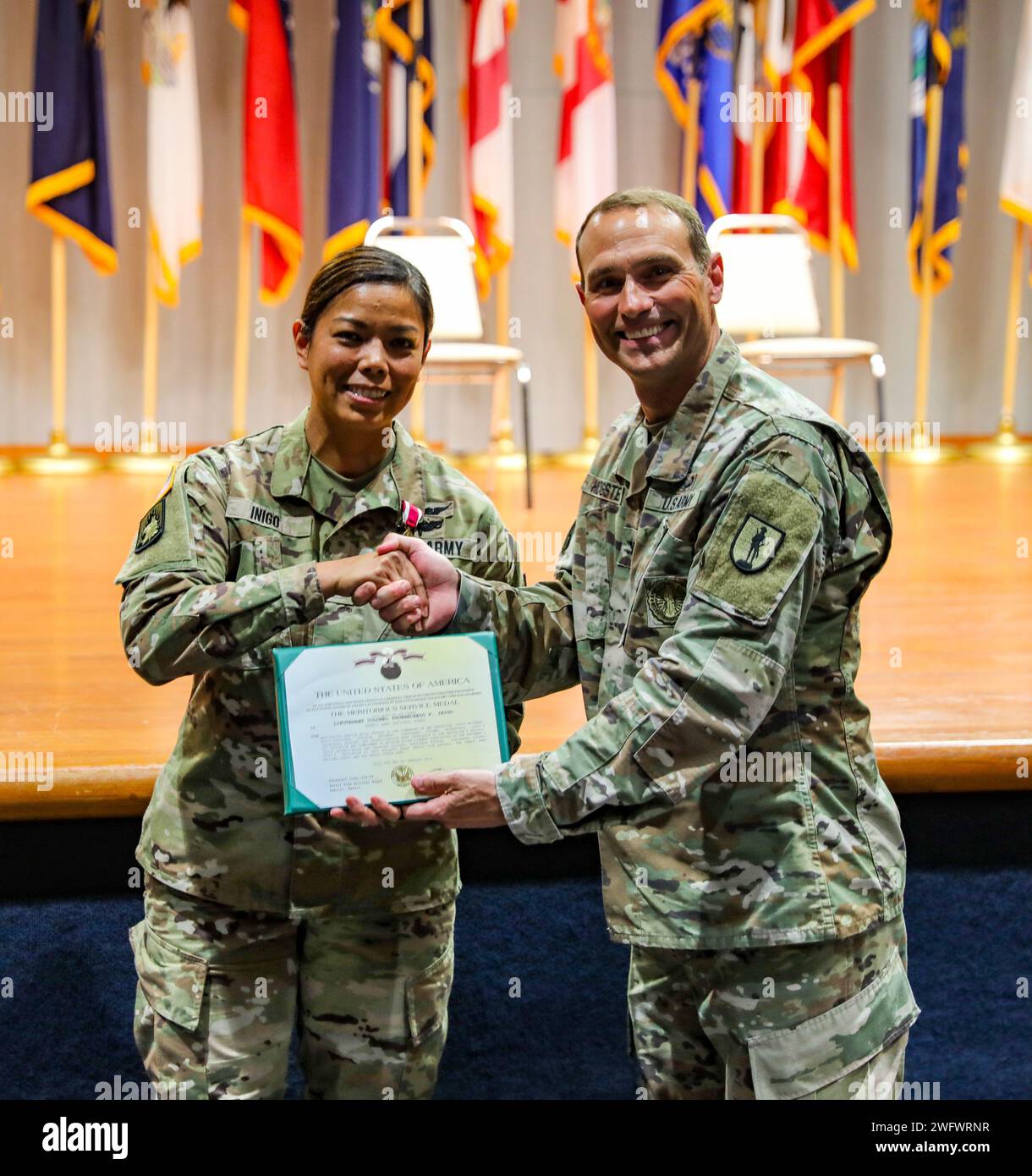 U.S. Army Col. Ronald D. Hogsten, commander of the 298th Regiment Multi-functional Regional Training Institute (RTI), Hawaii Army National Guard (HIARNG), presents a Meritorious Service Medal to Lt. Col. Phoebe Inigo, outgoing commander of the 2nd Battalion, 298th RTI, HIARNG, during the change of command ceremony in Waimanalo, Hawaii, January 7, 2024. The change of command ceremony is a time-honored tradition within the Army which commemorates the relinquishment of command by passing the unit’s colors from one officer to another. Stock Photo