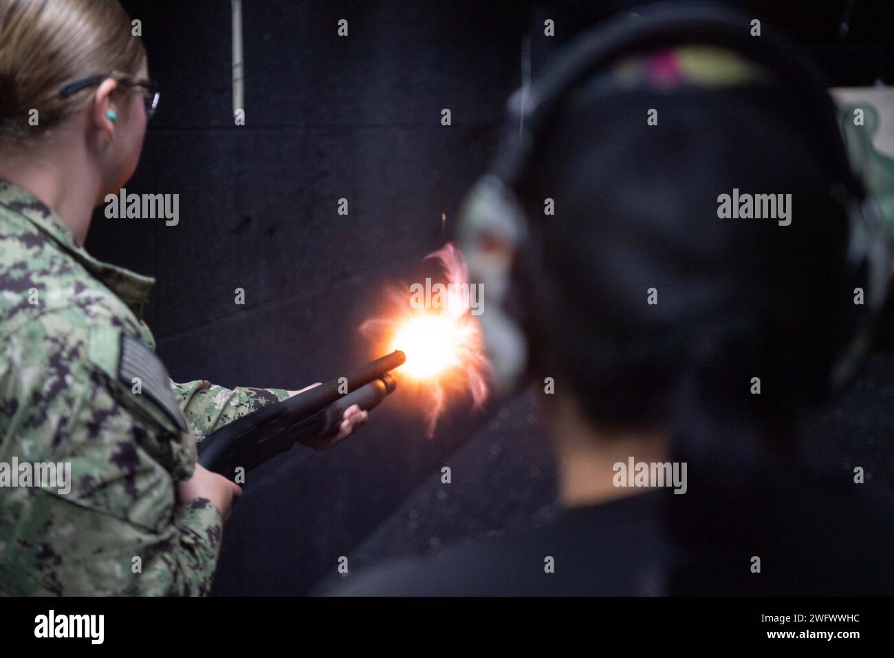 KEKAHA, Hawai‘i (Jan. 30, 2024) Boatswain's Mate Second Class Anna Henry fires an M500 service shotgun during gun qualification sustainment training at the indoor shooting range on Pacific Missile Range Facility (PMRF), Barking Sands, Kekaha, Hawaii. PMRF is the world's largest instrumented multi-domain range, capable of supporting surface, subsurface, air, and space operations simultaneously. Stock Photo