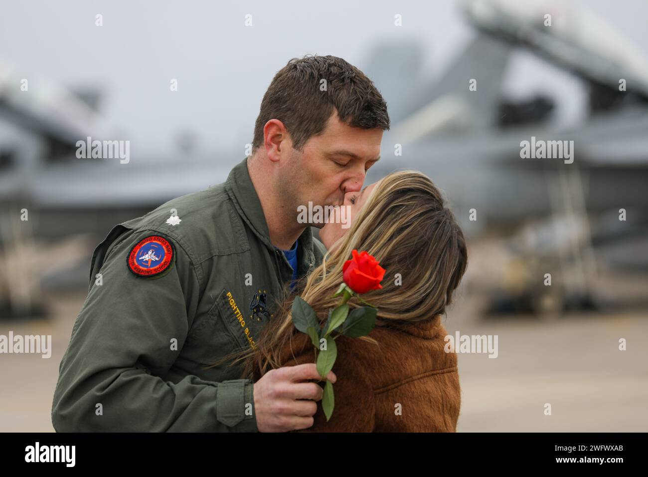 240115-N-YM590-1110 VIRGINIA BEACH, Va. (Jan. 15, 2024)- A pilot, assigned to the “Fighting Blacklions” of Strike Fighter Squadron (VFA) 213, reunites with his family after returning to Naval Air Station Oceana in Virginia, Jan. 15, following a more than eight-month deployment with the Gerald R. Ford Carrier Strike Group. While deployed, the squadron accomplished 1,943 sorties covering 3,137 flight hours with a 97% sortie completion rate. Stock Photo