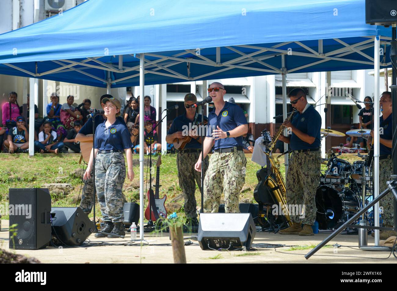 The Pacific Partnership Band, comprised of members from the U.S. Pacific Fleet Band and Royal Australian Navy Band, performs at Chuuk High School during a host nation outreach event in Chuuk, Federated States of Micronesia, as part of Pacific Partnership 2024-1, Jan. 15, 2024. Pacific Partnership, now in its 19th iteration, is the largest multinational humanitarian assistance and disaster relief preparedness mission conducted in the Indo-Pacific and works to enhance regional interoperability and disaster response capabilities, increase security stability in the region, and foster new and endur Stock Photo