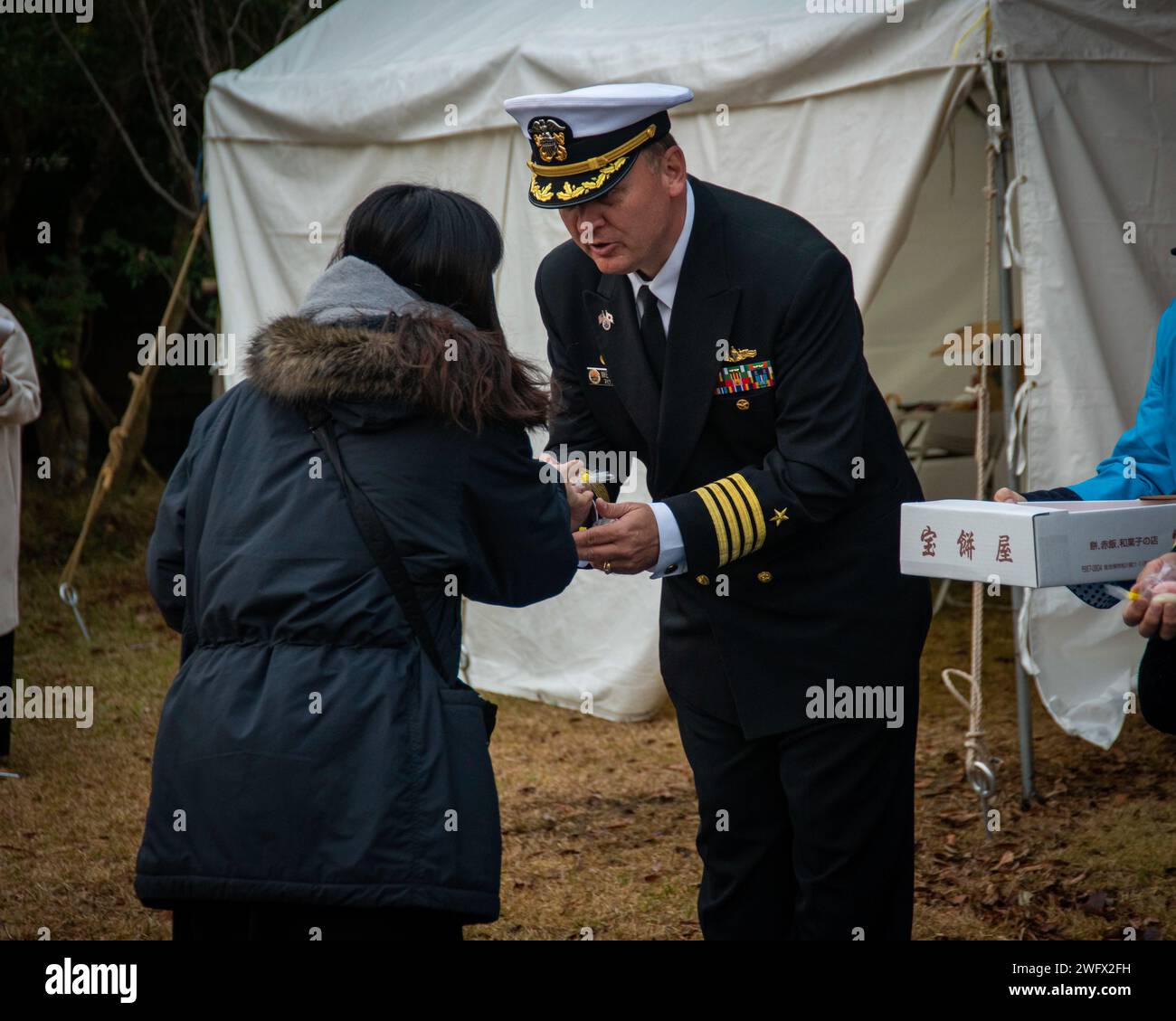 Capt. Michael Fontaine, Commander, Fleet Activities Sasebo, hands out ...