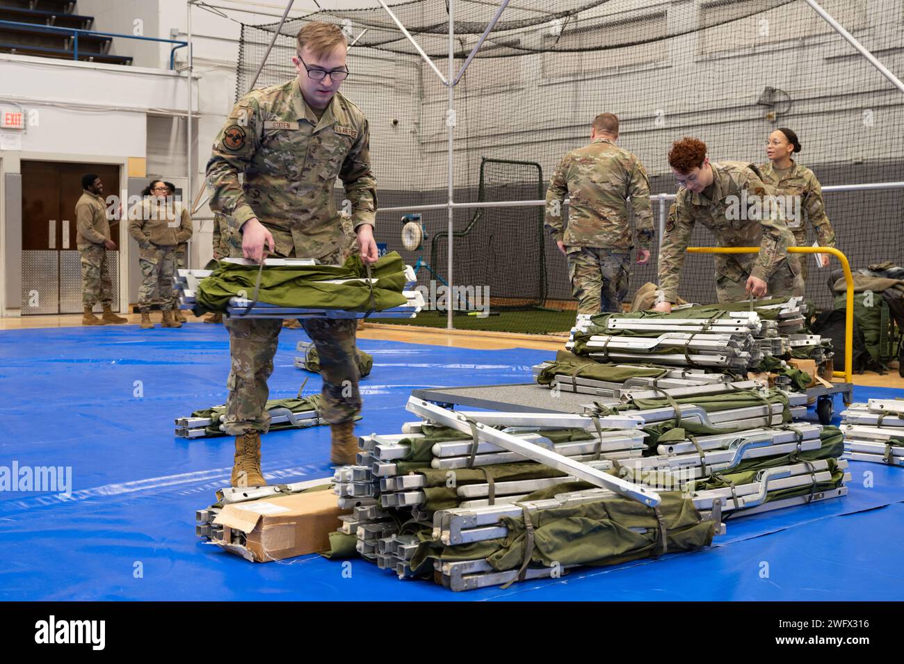 Airmen assigned to the 354th Force Support Squadron unload cots from a