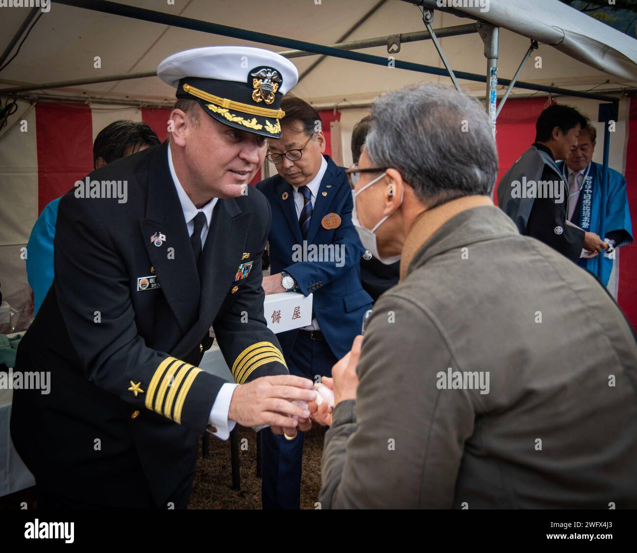 Capt. Michael Fontaine, Commander, Fleet Activities Sasebo, hands out ...