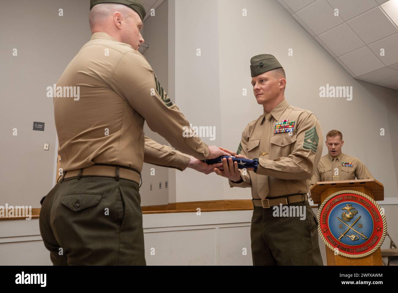 U.S Marine Corps Gunnery Sgt. William M. Moore, the acting first sergeant of Logistics Operations School, presents an American flag to 1st Sgt. Neill A. Sevelius during a retirement ceremony at Camp Gilbert H. Johnson, North Carolina, Jan. 11, 2024. The ceremony was held to recognize Sevelius’ 20 years of honorable service. Stock Photo