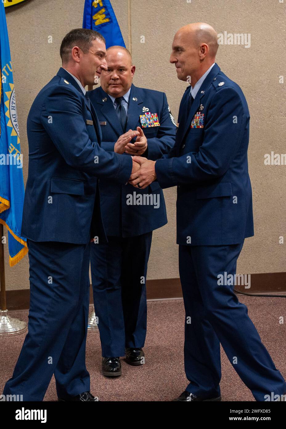 U.S. Air Force Lt. Col. Lance E. Niewenhuis (right), outgoing 114th Civil Engineer Squadron (CES) commander, congratulates Maj. Benjamin D. Shafer, incoming 114th CES commander during a change of command ceremony at Joe Foss Field, South Dakota, Jan. 7, 2024. The primary aim of the ceremony is to allow the team members to witness the formality of command change from one officer to another. Stock Photo