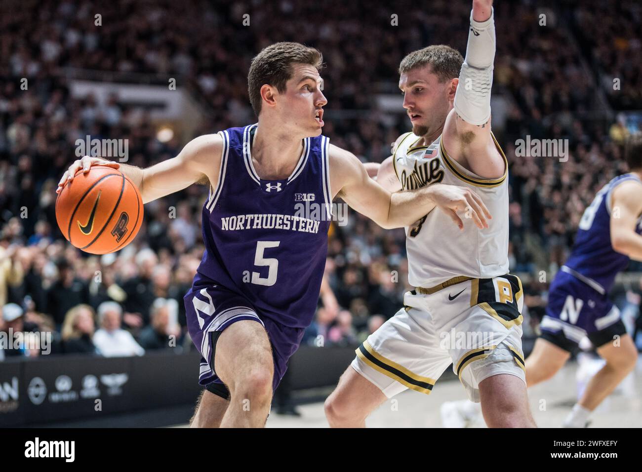 West Lafayette, Indiana, USA. 31st Jan, 2024. Northwestern Wildcats Guard RYAN LANGBORG (5) dribbles against BRADEN SMITH (0.0 of Purdue during the NCAA menÃs basketball game between the Northwestern Wildcats and the Purdue Boilermakers, Wednesday, Jan. 31, 2024, at Mackey Arena in West Lafayette, Ind. (Credit Image: © David Wegiel/ZUMA Press Wire) EDITORIAL USAGE ONLY! Not for Commercial USAGE! Stock Photo