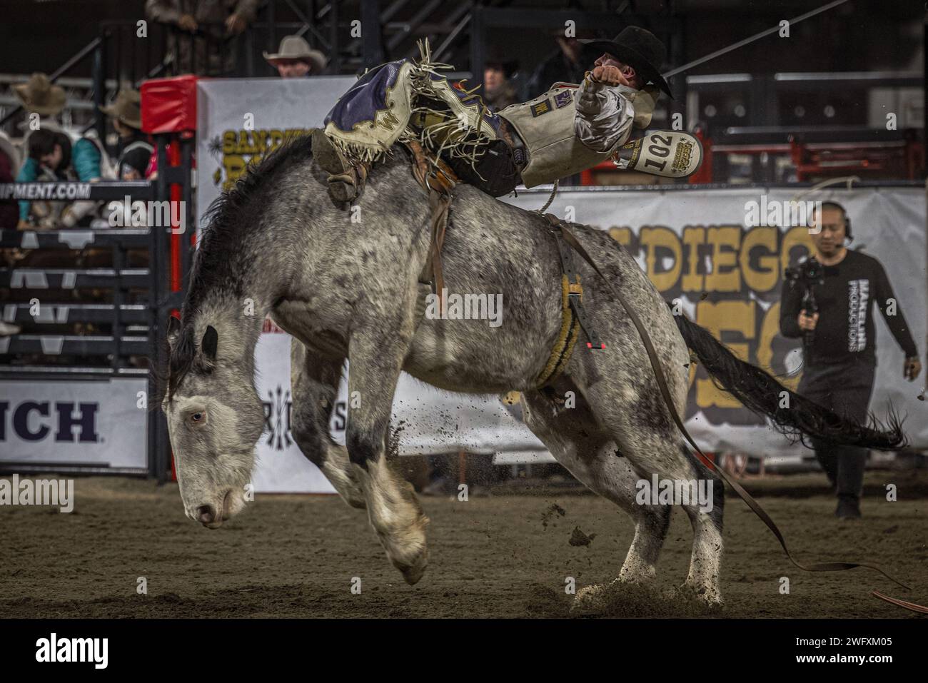 A participant in the San Diego Rodeo holds on to the reigns of a