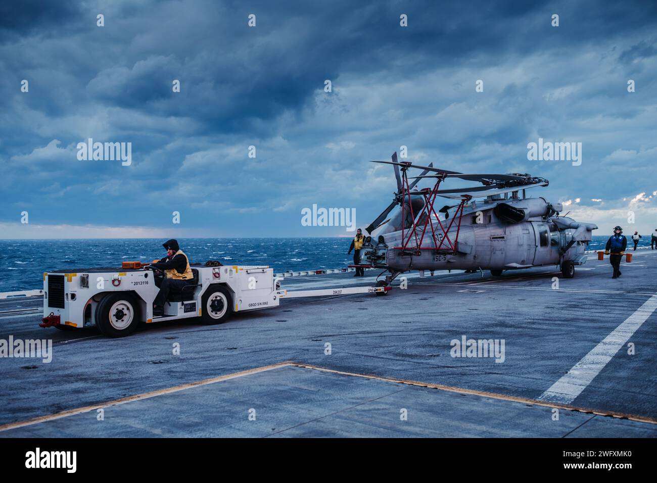 Sailors move an MH-60S Seahawk on the flight deck of Nimitz-class aircraft carrier USS George Washington (CVN 73) Jan. 19, 2024. USS George Washington is underway in support of carrier qualifications. Stock Photo