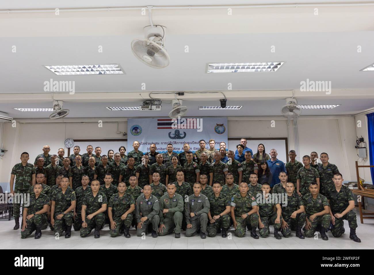 Thailand Mine Action Center (TMAC) staff, Humanitarian Mine Action (HMA) team members, HMA students, and the Golden West Foundation, pose for a photo during an opening ceremony for the HMA Thailand Explosive Ordnance Disposal (EOD) level 1-2 course at Fort Bhanurangsi, Ratchaburi, Thailand, Jan. 8, 2024. Royal Thai and American Armed Forces work together to train TMAC students in EOD level 1-2 in order to develop an EOD capacity to assist TMAC’s mission of becoming landmine free. This partnership is aligned with the U.S. Department of Defense’s Humanitarian Mine Action Program, which assists p Stock Photo