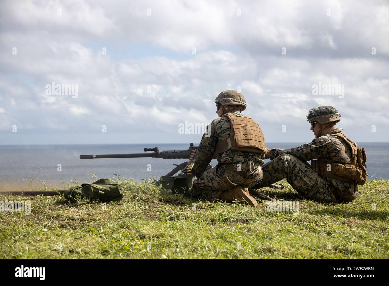 U.S. Marines with Marine Wing Support Squadron (MWSS) 174, Marine Aircraft Group 24, 1st Marine Aircraft Wing, fire M240-B and M2 .50-caliber machine guns at the Marine Corps Air Station Kaneohe Bay range, Hawaii, Jan. 16, 2024. The training provided an opportunity for Marines with MWSS-174 to get hands-on training and familiarization with the employment of crew-served weapons. Stock Photo