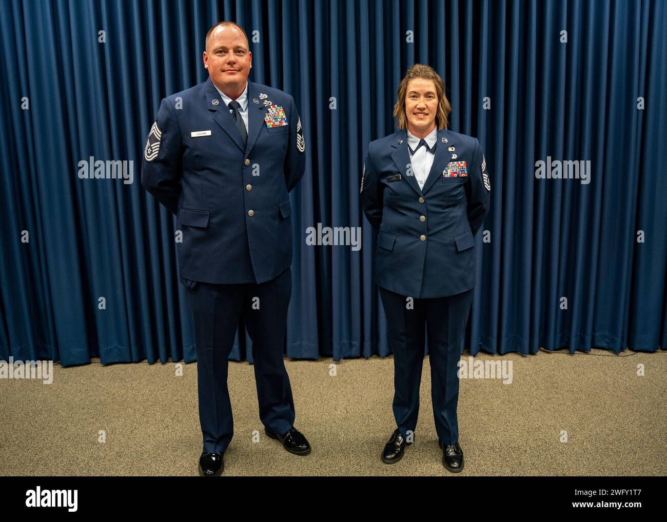 Chief Master Sgt. Alan Tuschen (left), Wing installation manager with the 114th Civil Engineer Squadron, and Chief Master Sgt. Kristy Loen, superintendent of the 114th Command Post, pose for a photo during a chief master sergeant induction ceremony at Joe Foss Field, South Dakota, Jan. 7, 2023.  These honorees have been inducted into the highest enlisted rank and will assume strategic leadership positions with significant influence throughout the base. Stock Photo
