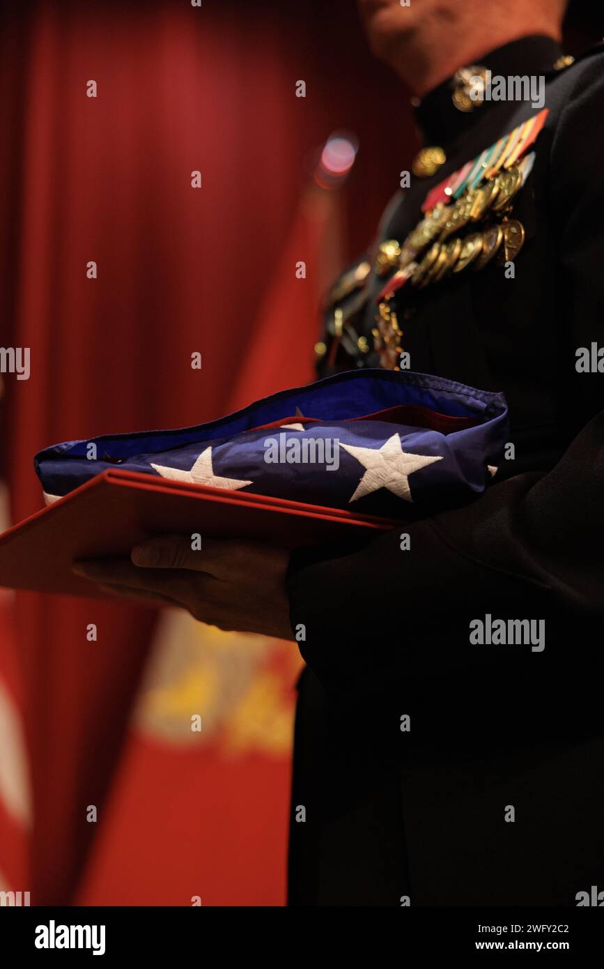 U.S. Marine Corps Col. Garret Miller, former Assistant Chief of Staff of Facilities, Marine Forces Reserve, receives a flag at his retirement ceremony at the National World War II Museum in New Orleans, Louisiana, Jan. 5, 2024. The folded United States Flag is traditionally given at retirement ceremonies as it is the symbol of our great nation to which the retiree has served faithfully. Miller is a native of Charlotte, North Carolina, and a graduate of Charlotte Christian High School. Stock Photo