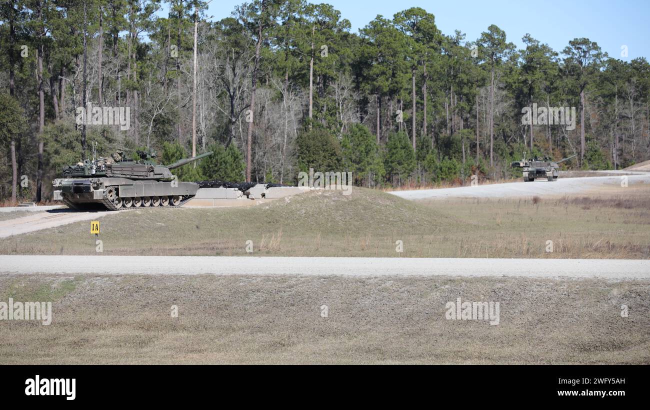 U.S. Army Staff Sgt. Eric Gyarko, a tank commander assigned to 2nd Battalion, 7th Infantry Regiment, 3rd Infantry Division, looks out the driver's hatch of a M1A2 Abrams tank during gunnery table VI at Fort Stewart, Georgia, Jan. 30, 2024. In gunnery table VI, tank crews use a variety of ammunition including armor piercing training rounds, 50. cal bullets and salvo rounds. (U.S. Army photo by Pfc. Benjamin Hale) Stock Photo
