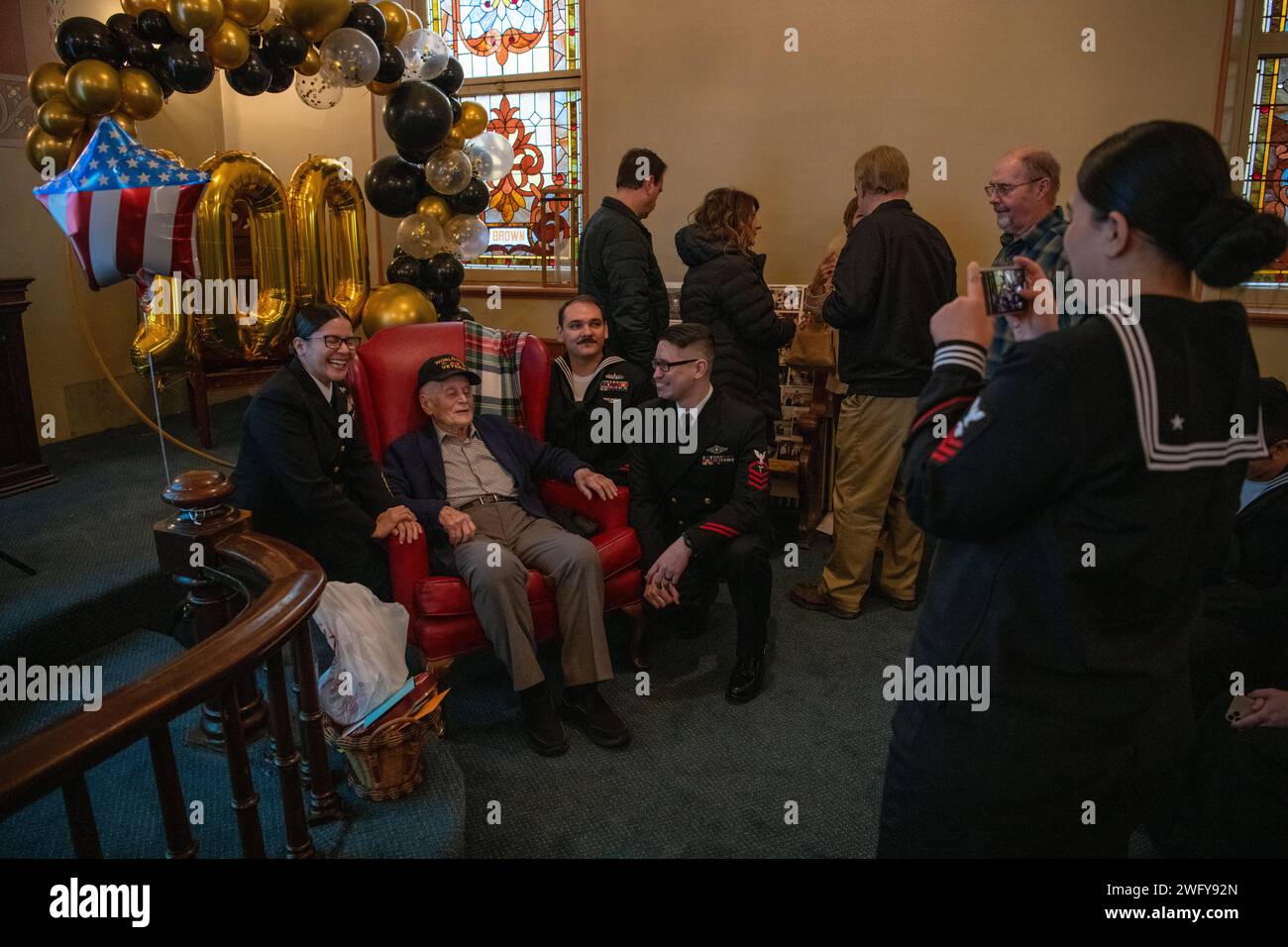 World War II veteran Albert Wend poses for a photo with Sailors during