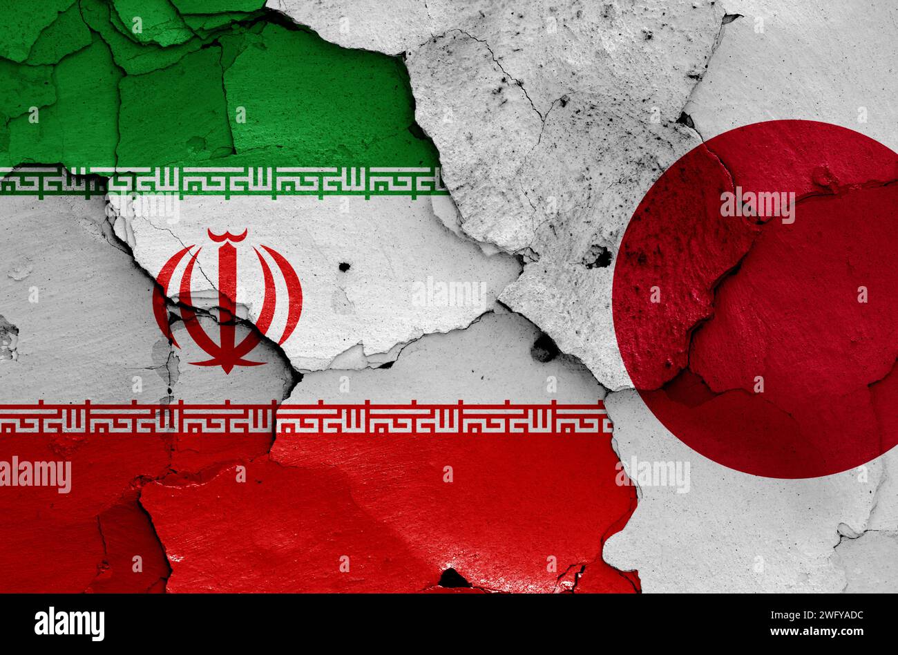 flags of Iran and Japan painted on cracked wall Stock Photo