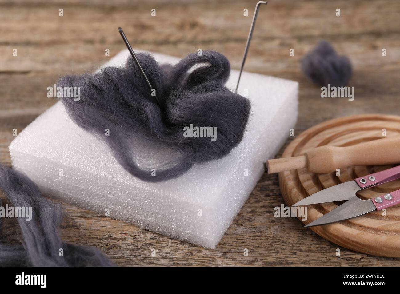 Felting tools and wool on wooden table, closeup Stock Photo