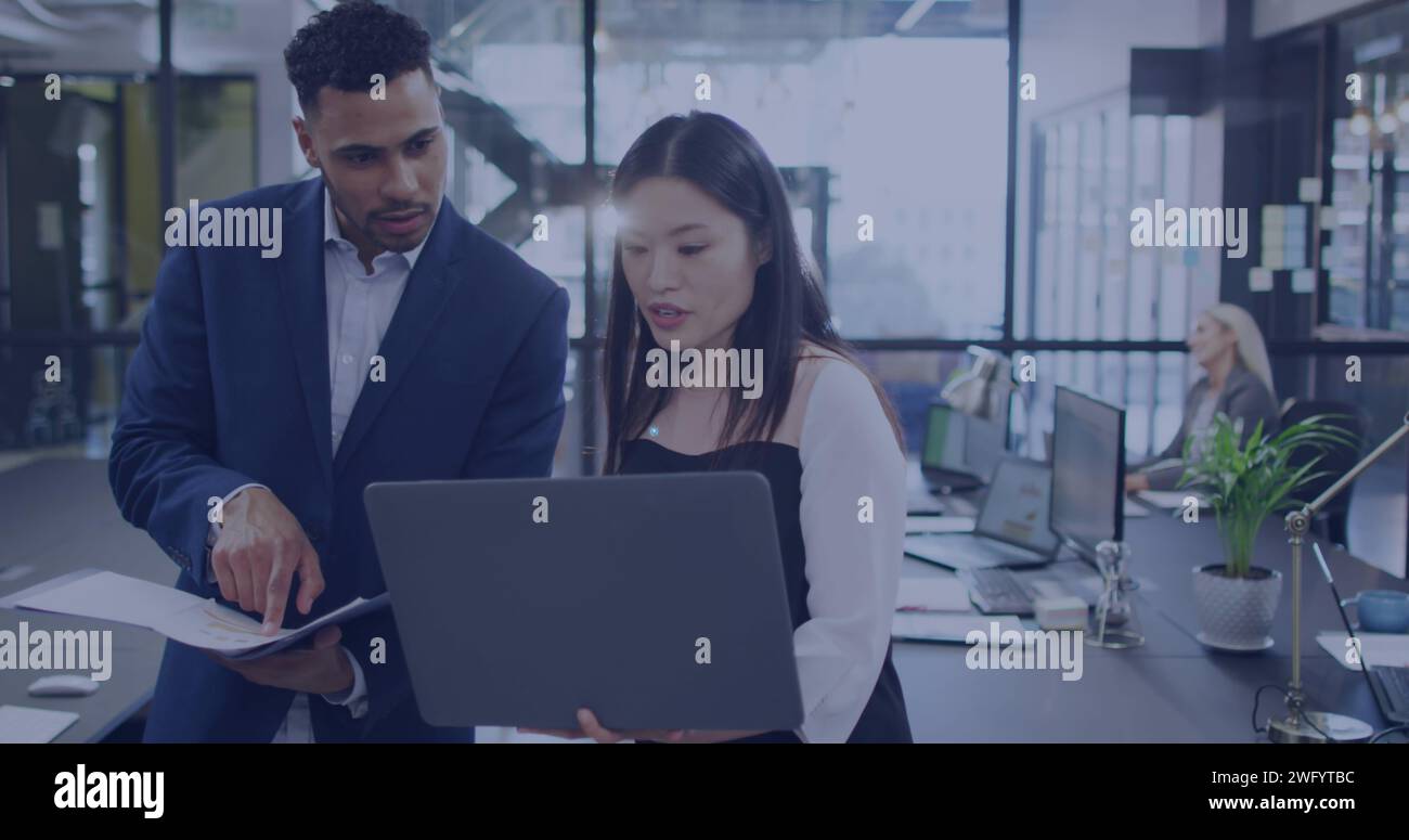 Asian woman and young biracial man collaborate in a modern office Stock Photo