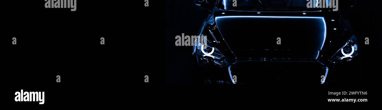 Front view silhouette of black modern car with headlights on black background. copy space Stock Photo
