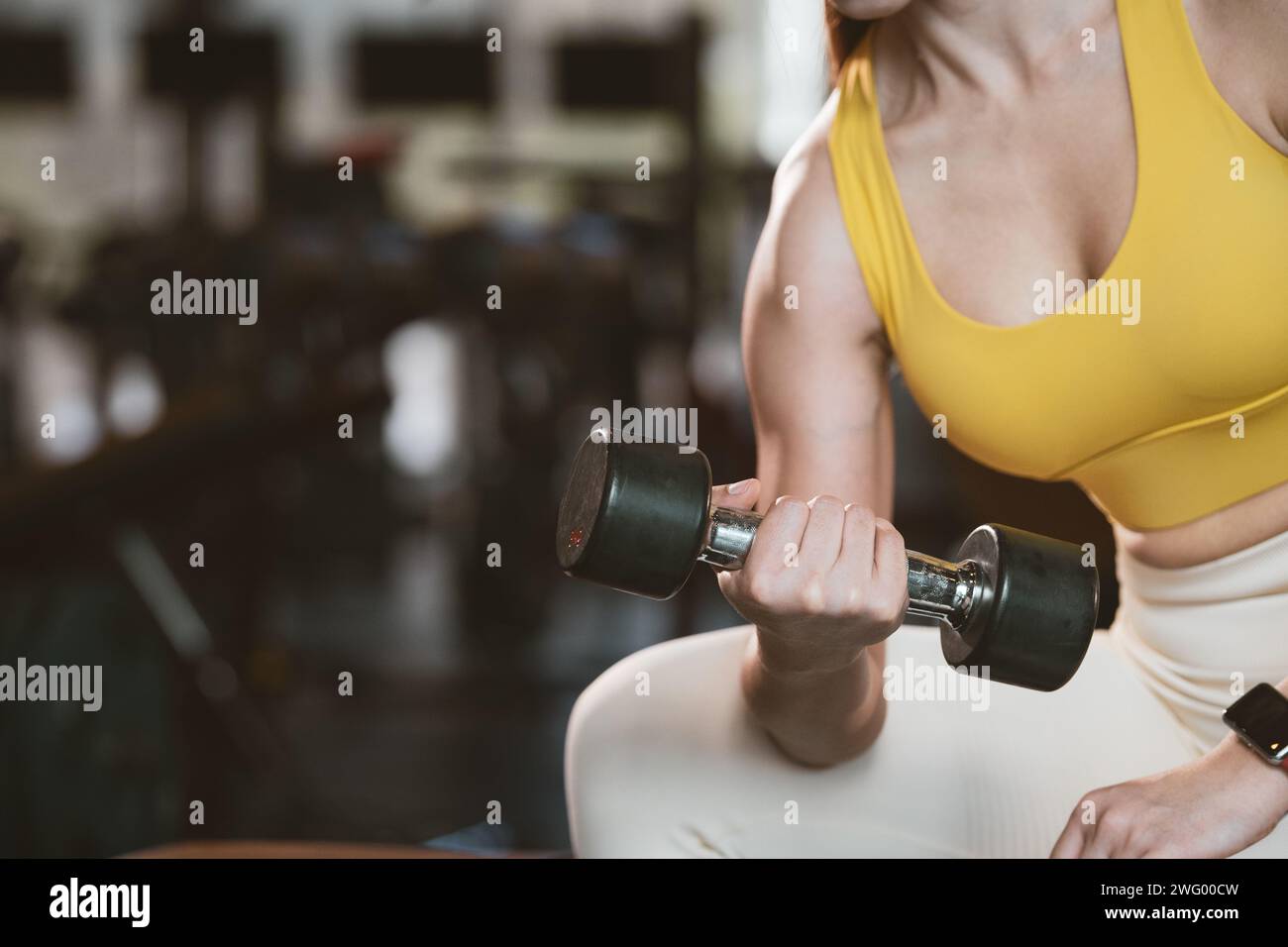 Fitness asian woman doing exercise and lifting dumbbells weights at sport gym. Stock Photo