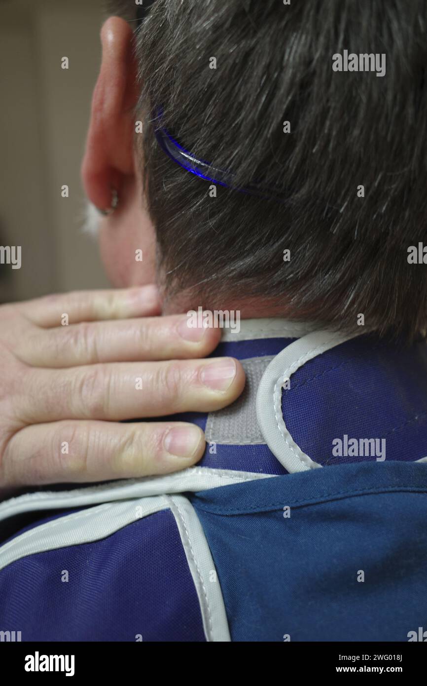 A close-up of a man experiencing neck pain Stock Photo