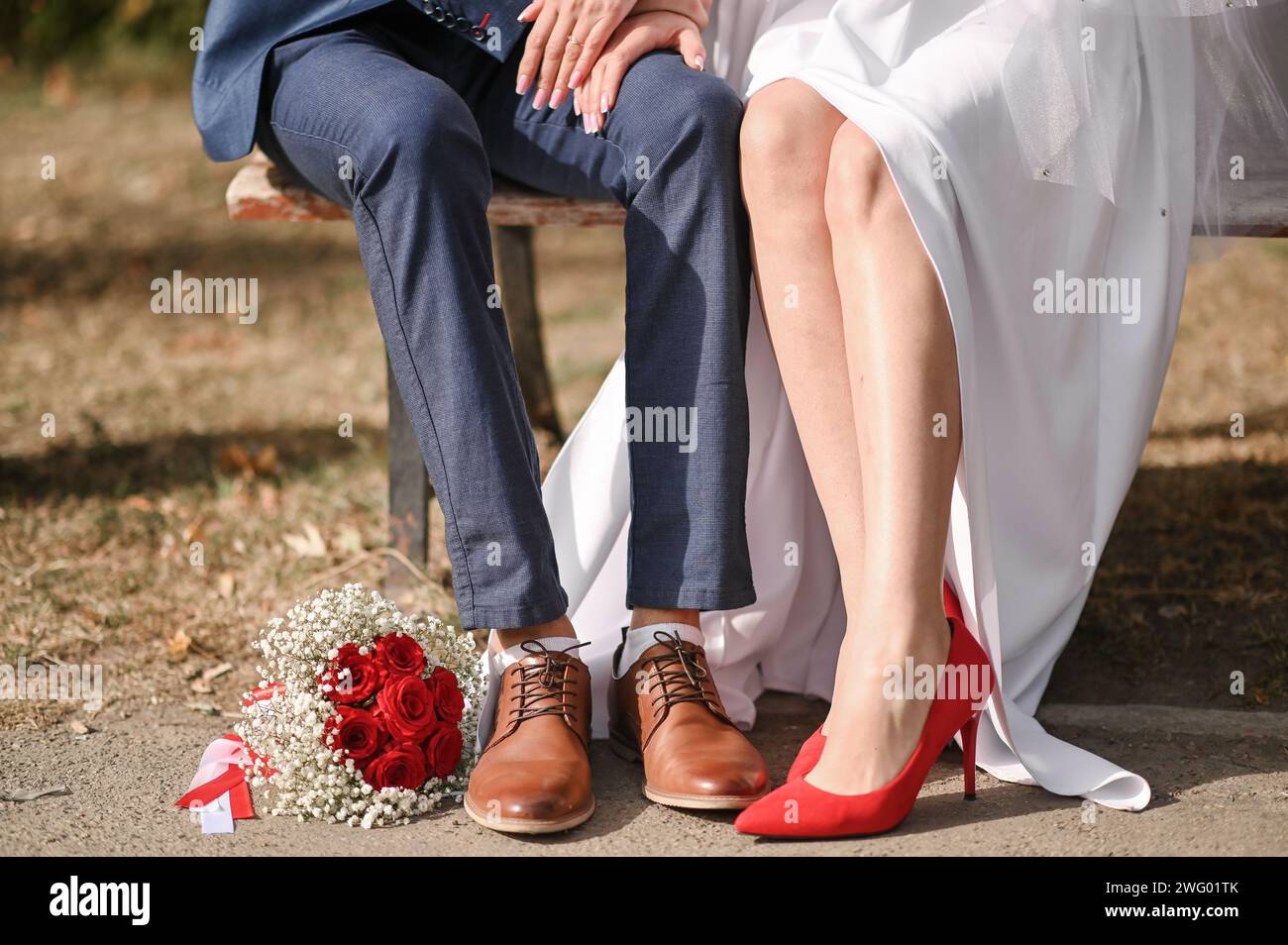 The bride and groom are sitting on a park bench Stock Photo - Alamy