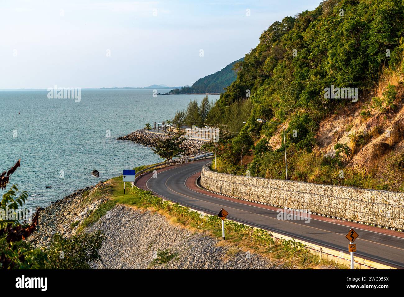 Beautiful view of evening sunset at the Noen Nangphaya view point looking out to the ocean and winding road along the coast in Chonburi, Thailand Stock Photo