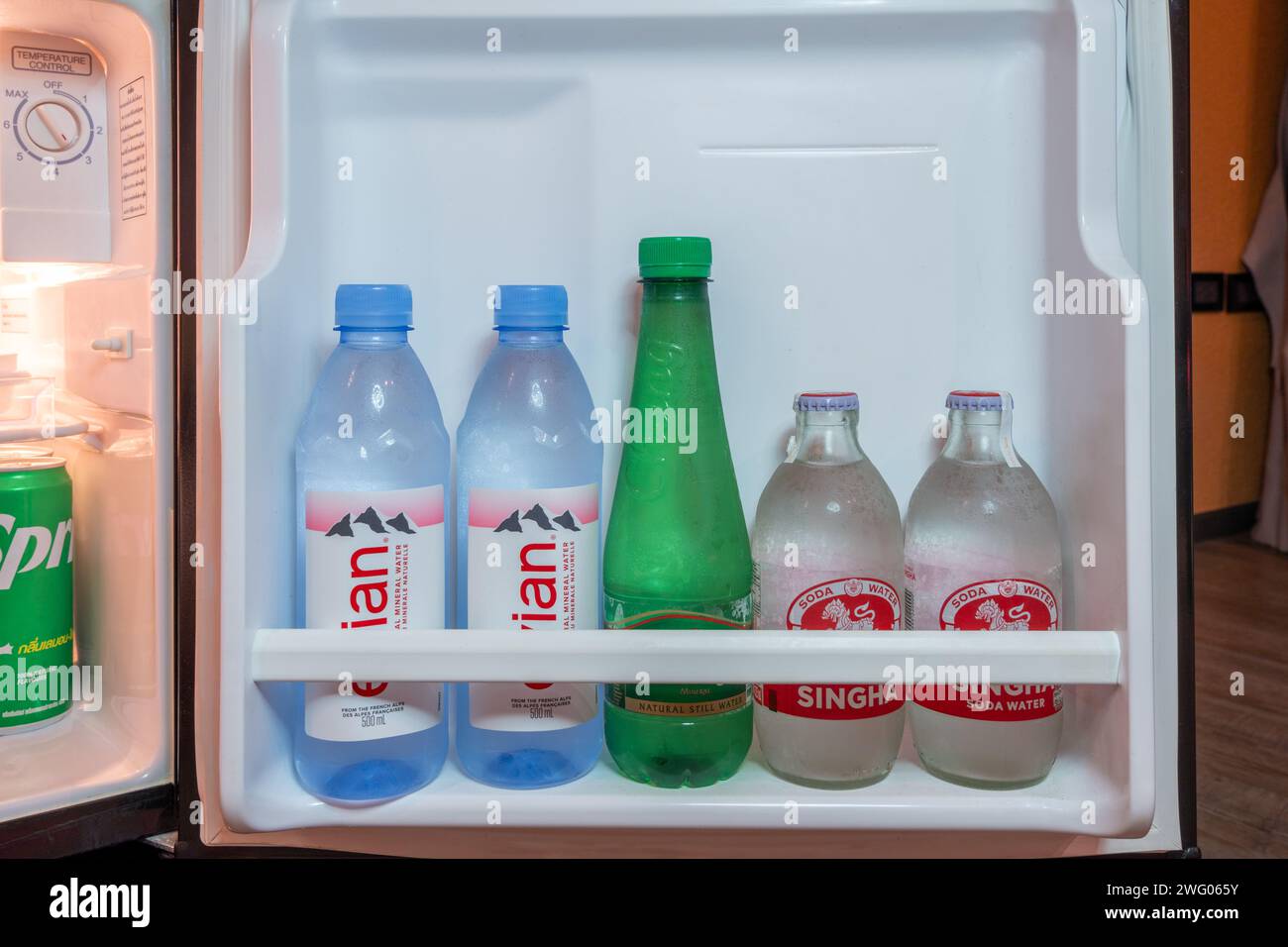Trad, Thailand - January 24, 2024 - Cold bottles of water and soda stacking inside a small refrigerator door Stock Photo