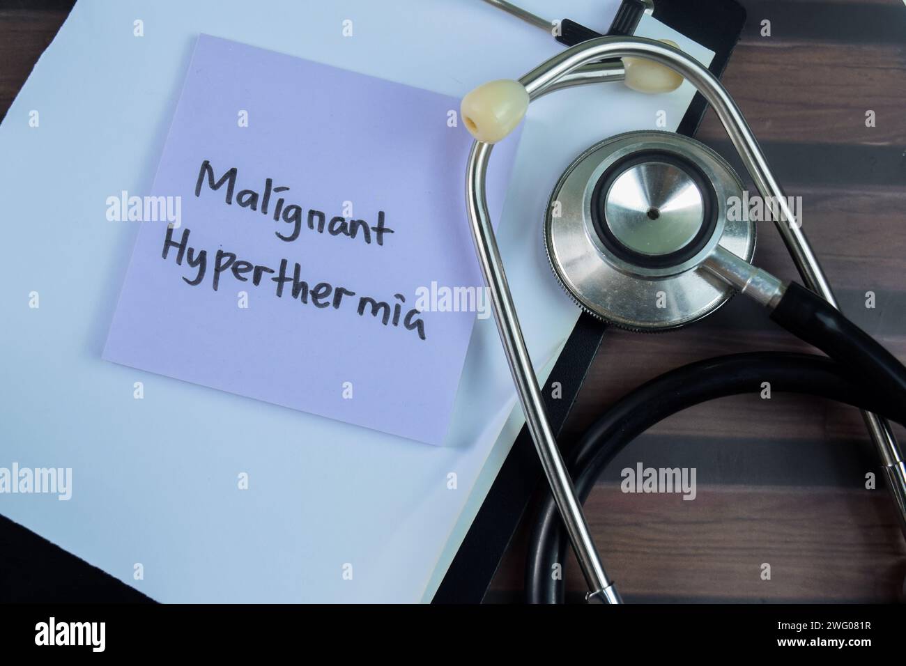 Concept of Malignant Hyperthermia write on sticky notes with stethoscope isolated on Wooden Table. Stock Photo