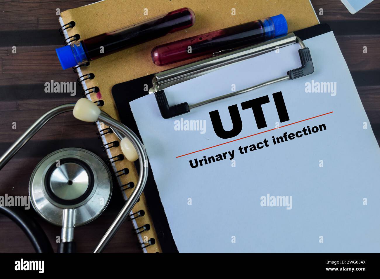 Concept of UTI - Urinary Tract Infection write on paperwork with stethoscope isolated on wooden background. Stock Photo
