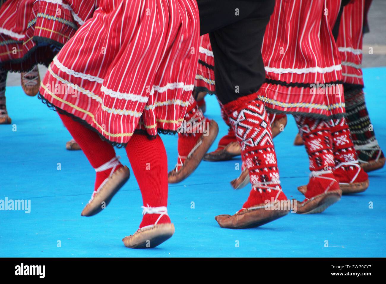 Group of individuals in elegant attire exchanging glances at a social gathering: Serbian folk dancers in a festival Stock Photo
