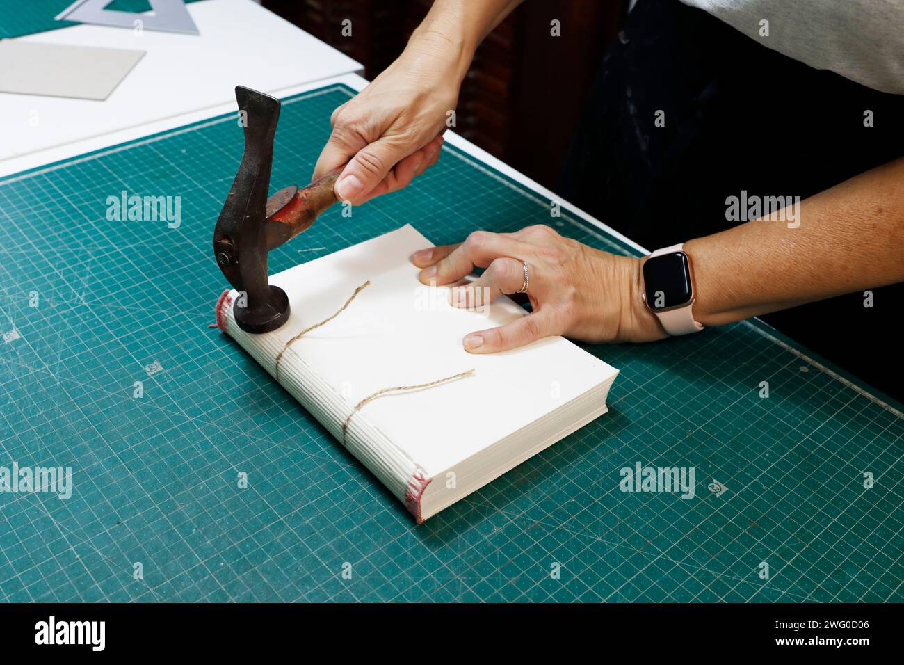 Person cutting paper and attaching nails to fabric Stock Photo Alamy