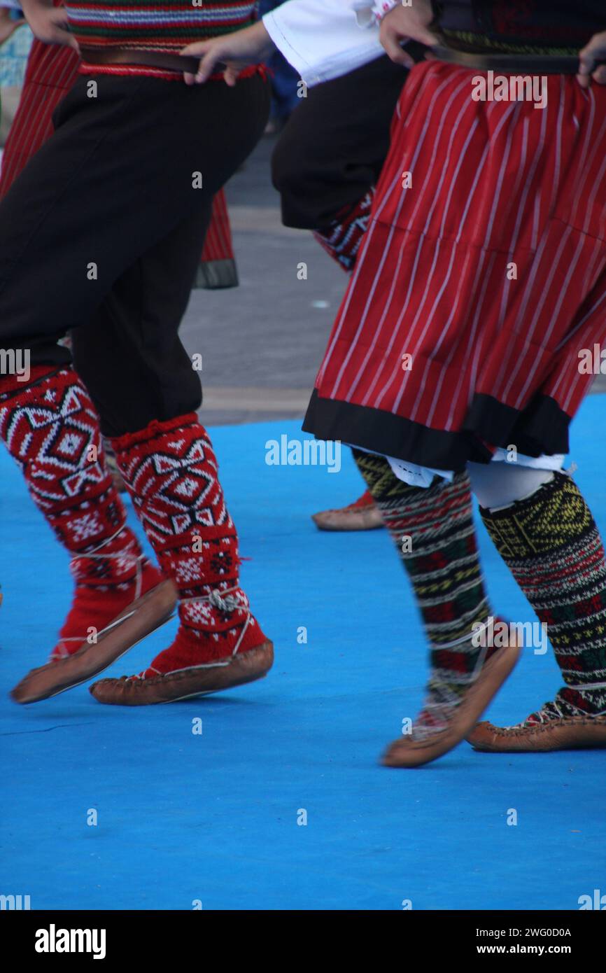 Group of individuals in elegant attire exchanging glances at a social gathering: Serbian folk dancers in a festival Stock Photo