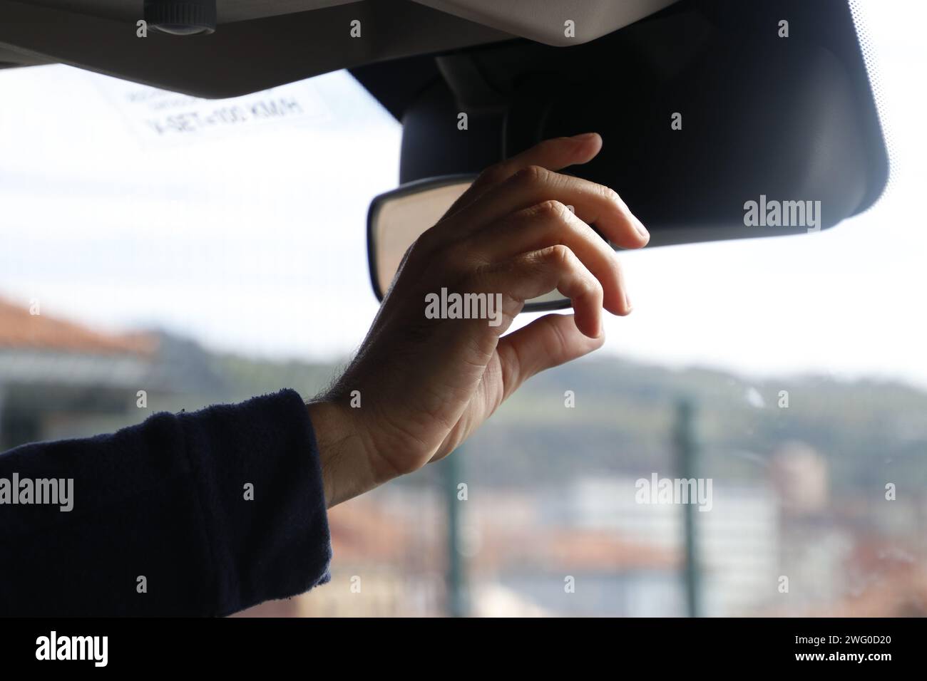 Man driving car with hands on side mirror Stock Photo