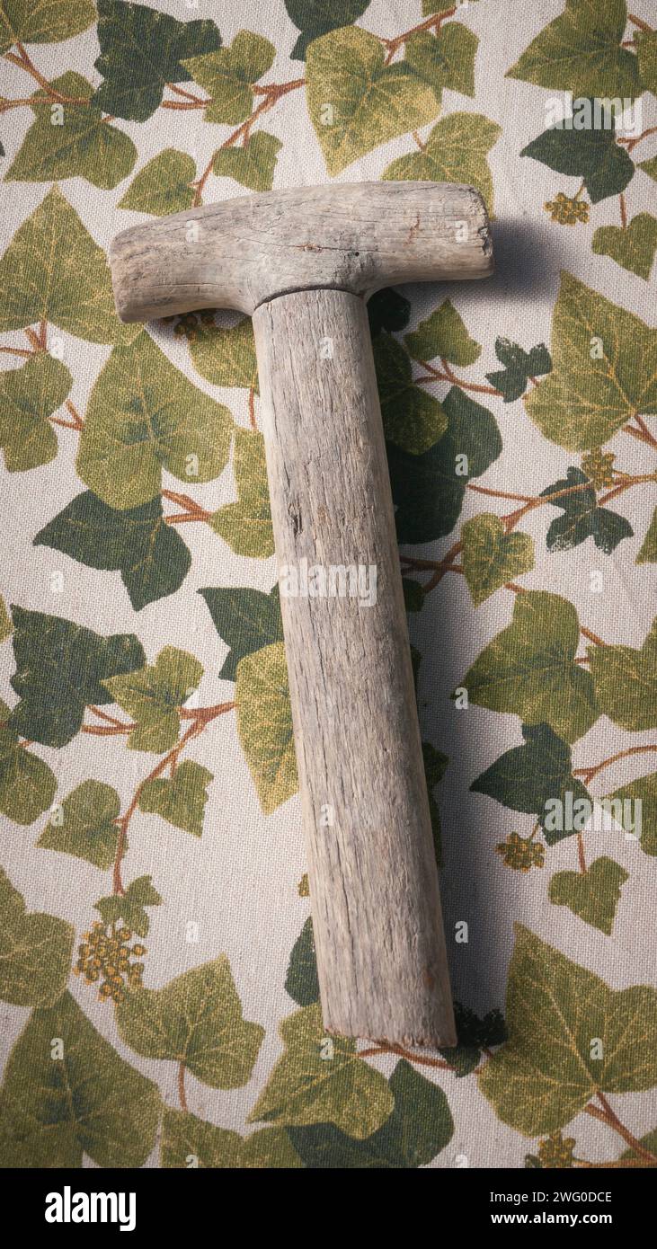 Wooden tool handle on leaves print fabric Stock Photo