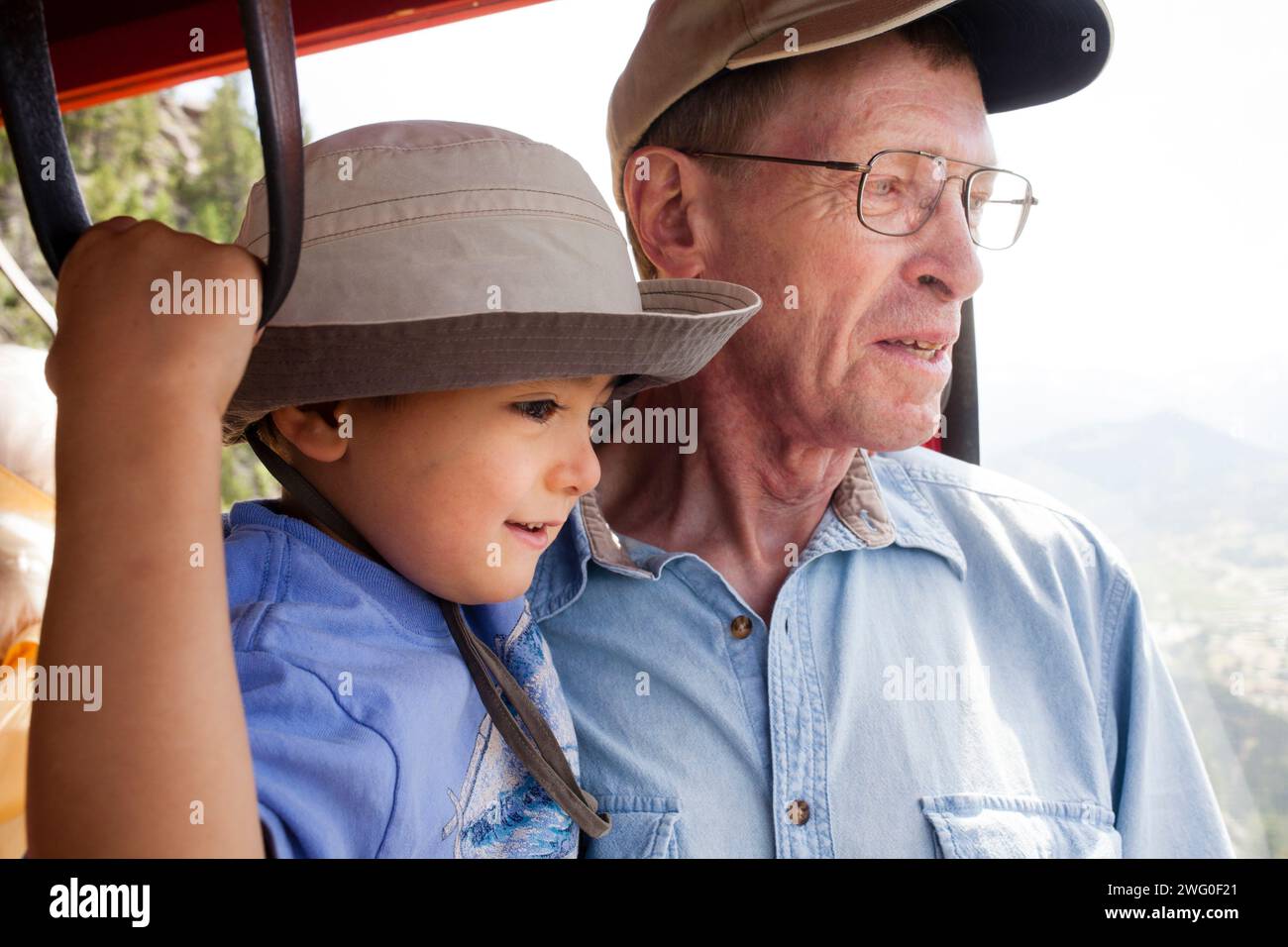 A grandfather holds his four year old grandson while riding the Estes Park Aerial Tramway (gondola). Stock Photo