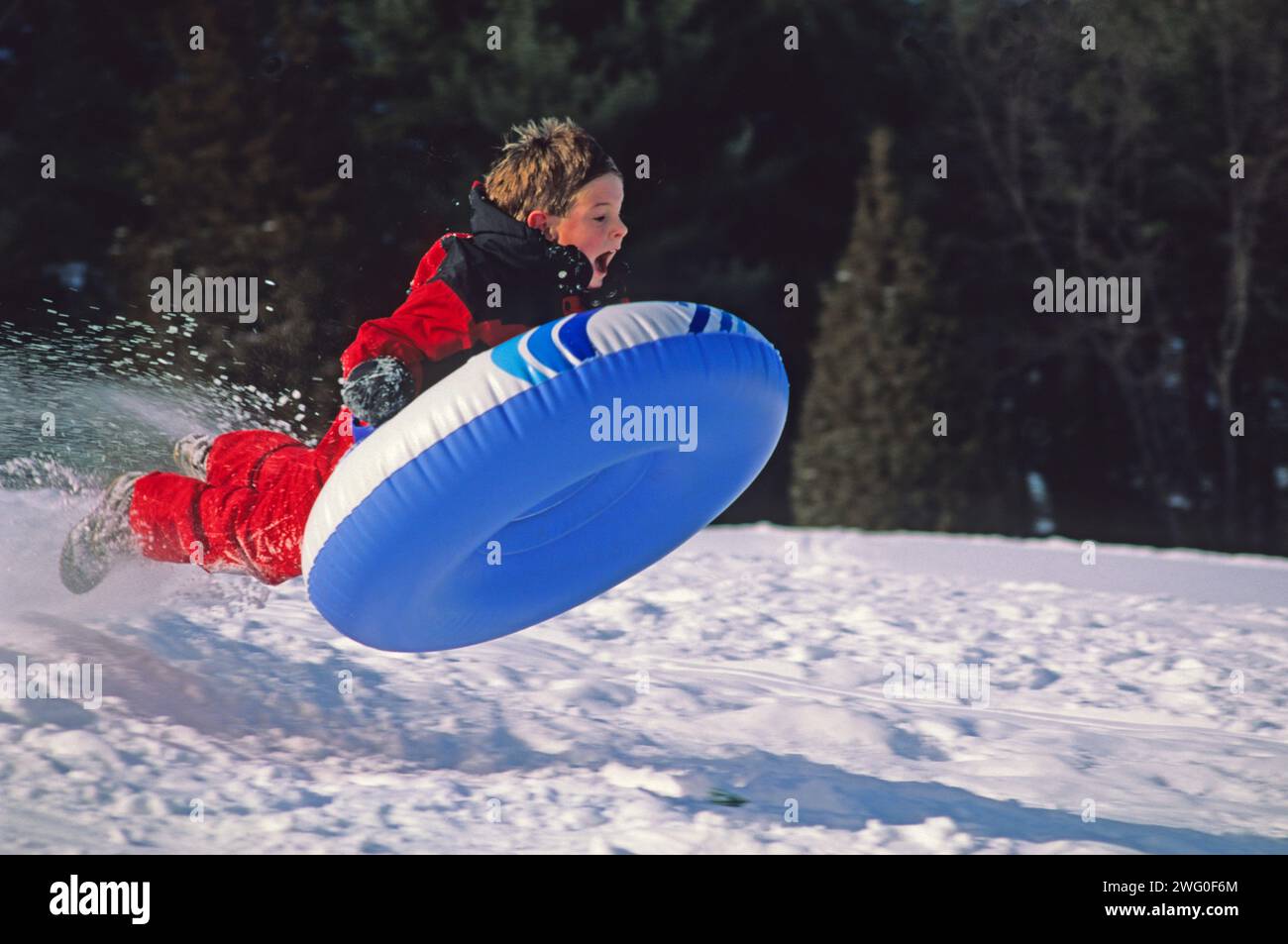 Young boy sledding in New Hampshire Stock Photo