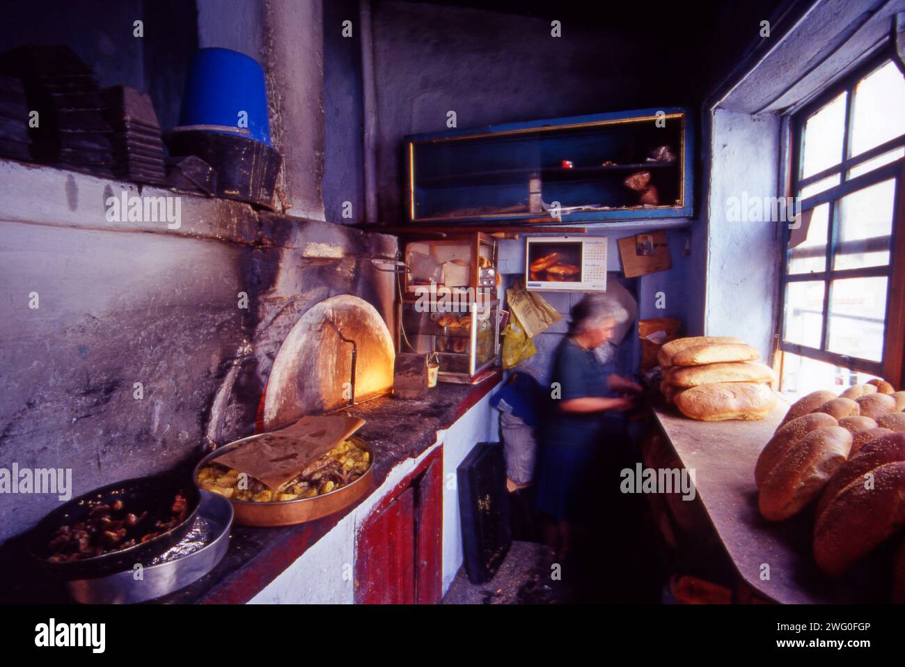 Seemingly untouched by time, the bakery in Vatoussa supplies the locals with their daily bread, fresh and warm from the oven. Stock Photo