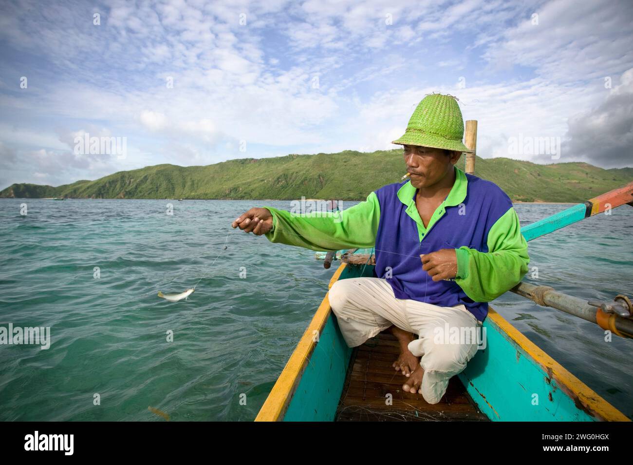 A fisherman catches a small fish in Kuta, Lombok, Indonesia. Stock Photo