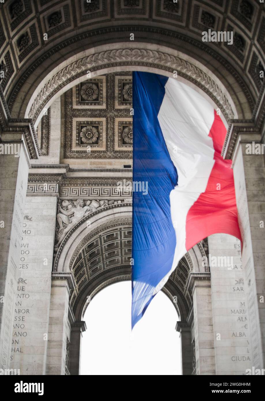 The French flag hangs from the Arc de Triomphe, Paris, France. Stock Photo