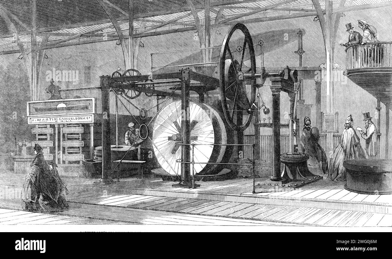 The International Exhibition: Samuelson's machinery for crushing and grinding linseed, extracting the oil, and making oilcake, 1862. 'Every one knows how important a part oilcake plays in the production of Christmas beef and mutton...but everybody does not know how it is produced...First, there is a mill in which the linseed is ground to a moderately fine meal; it is then placed under two immense circular stones set up vertically, called edge-runners; these, by the aid of a powerful steam-engine, are made to revolve round an upright shaft, while at the same time they turn upon their own centre Stock Photo