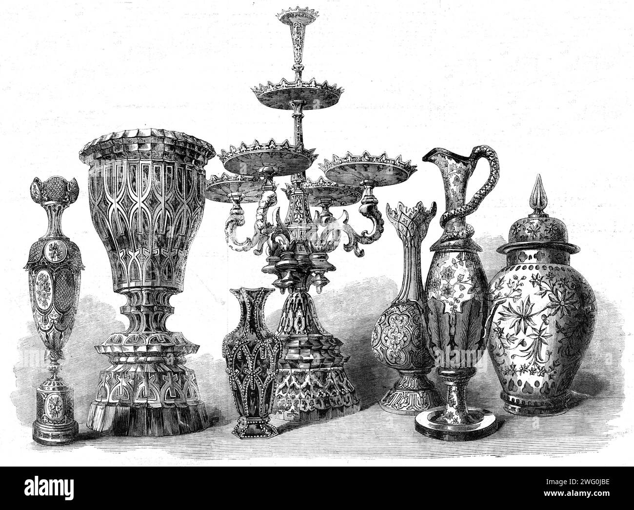 The International Exhibition: Bohemian glass, by Harrach of Bohemia, and Hofmann of Prague, in the Austrian Court, 1862. 'The central object...has its dishes and central column wrought of red glass cut into flat facets enriched with burnished gold...Both the large urn, or cup-shaped vessel, and the small vase in front of the dessert-dish, are in imitation malachite, the opaque striae and convolutions resulting from white glass being mingled with the dark green material of which they are formed...The elongated vase mounted on a pedestal...is formed of transparent green glass, which has been cov Stock Photo