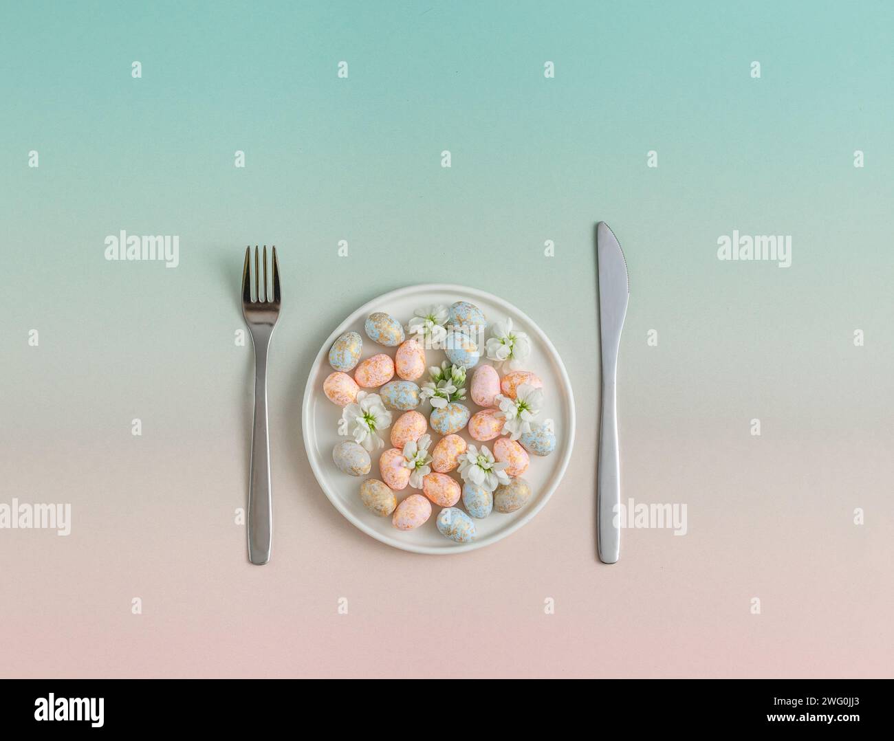 Pastel easter Eggs on Plate with Utensils. easter concept Stock Photo