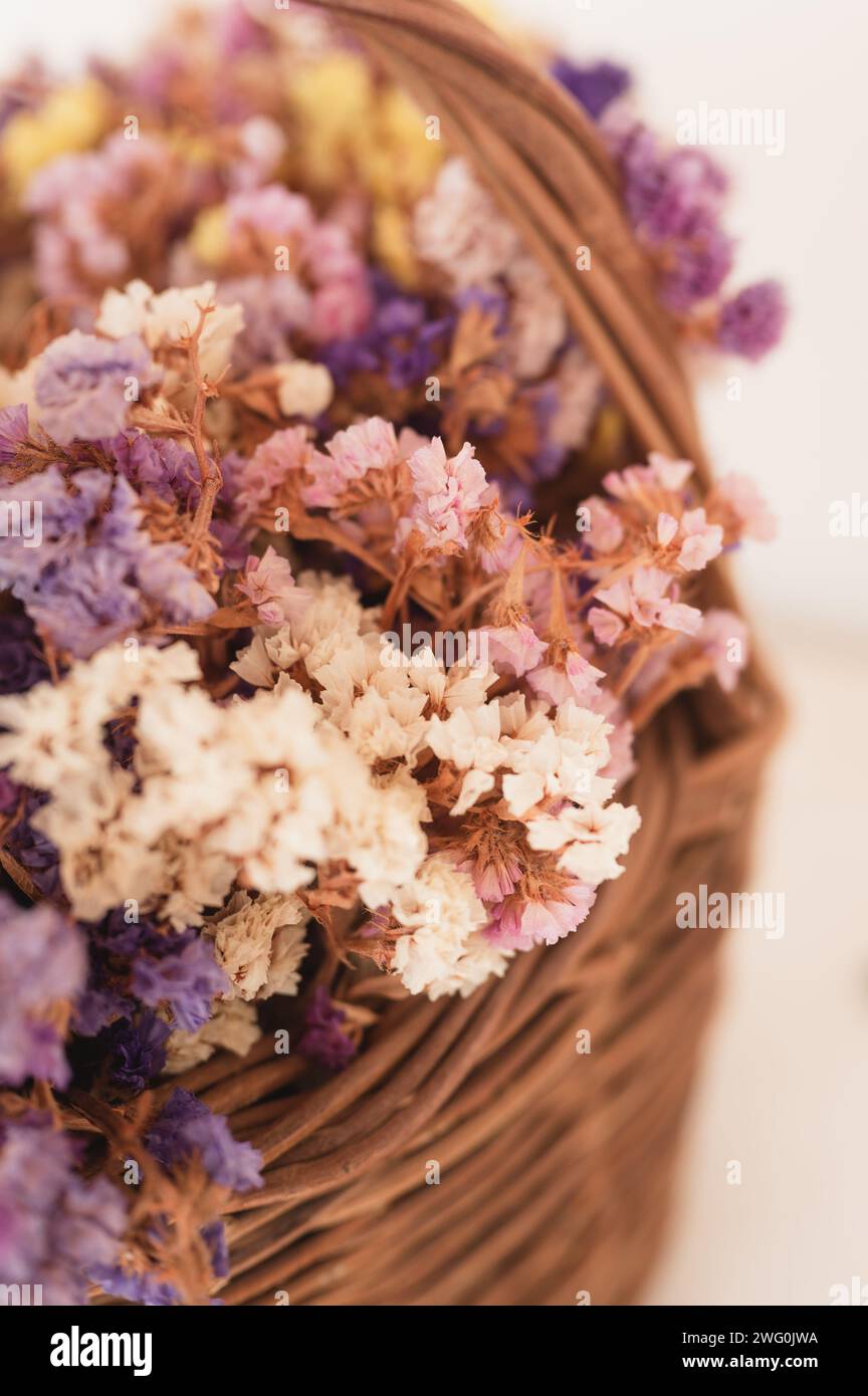 Close up of colorful Statice flowers (Limonium) in a woven basket Stock Photo