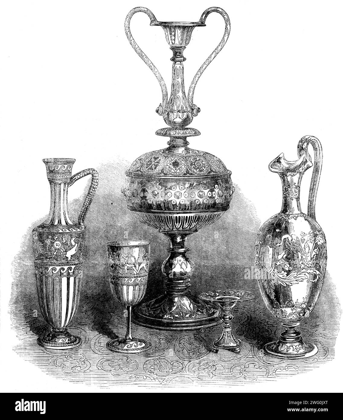 The International Exhibition: group of glass, by Messrs. Phillips, of Oxford-street and Bond-street, 1862. 'The shape [of the central vase], while novel, is good, the division into primary parts and the relation of the parts to each other, being well managed. The enrichment is skilfully composed and is beautiful in its parts, and the jewelling is well managed...The ornament applied to this vase is of a Gothic character, and is in tolerably good keeping throughout. The vase to the right is of a fine classic form, and has a somewhat Roman character. The engraving is very fine, hut the ornament i Stock Photo