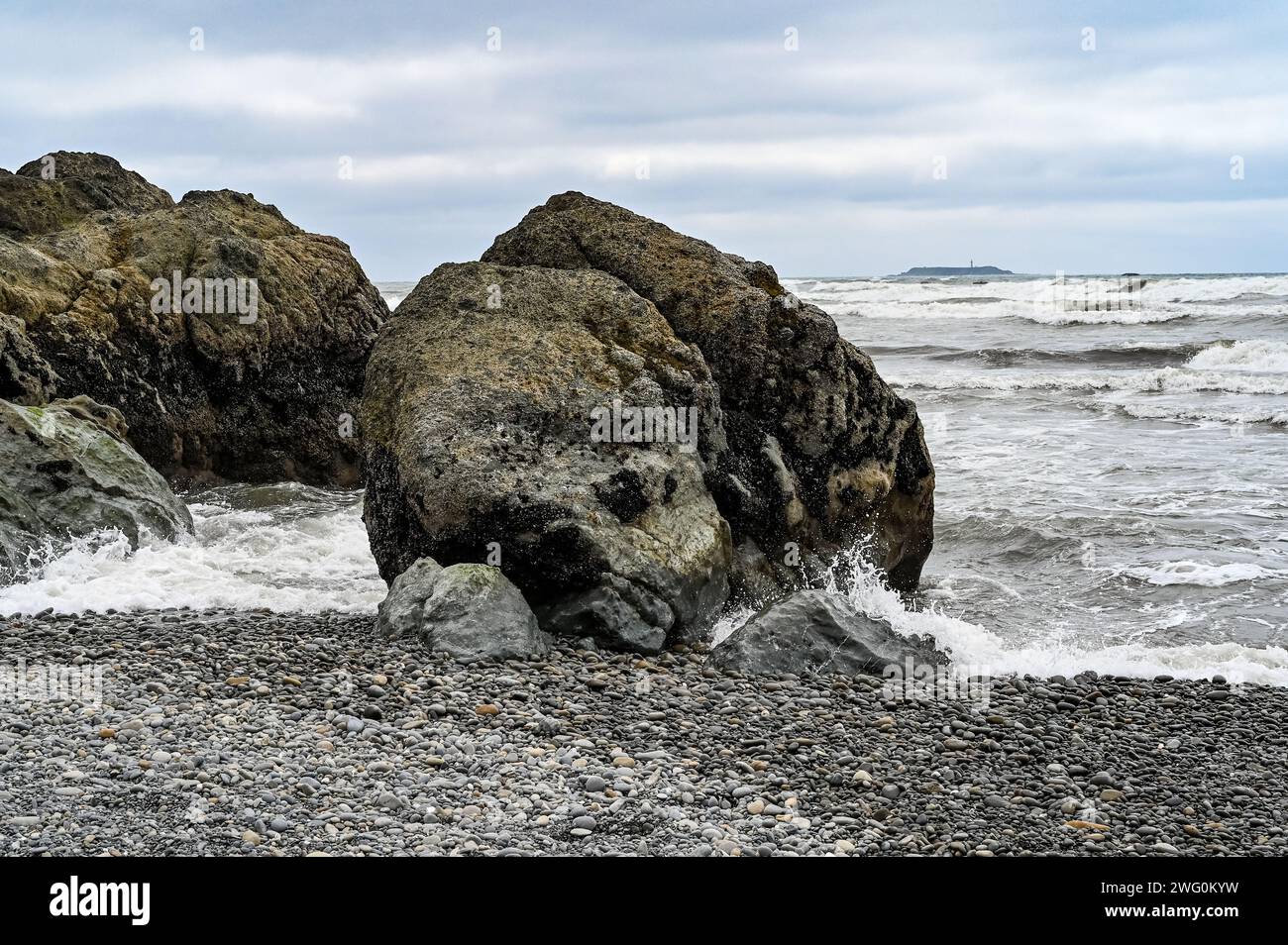 Rocks washed ashore on beach by ocean Stock Photo - Alamy